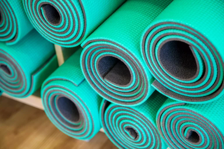 Green yoga mats on a shelf